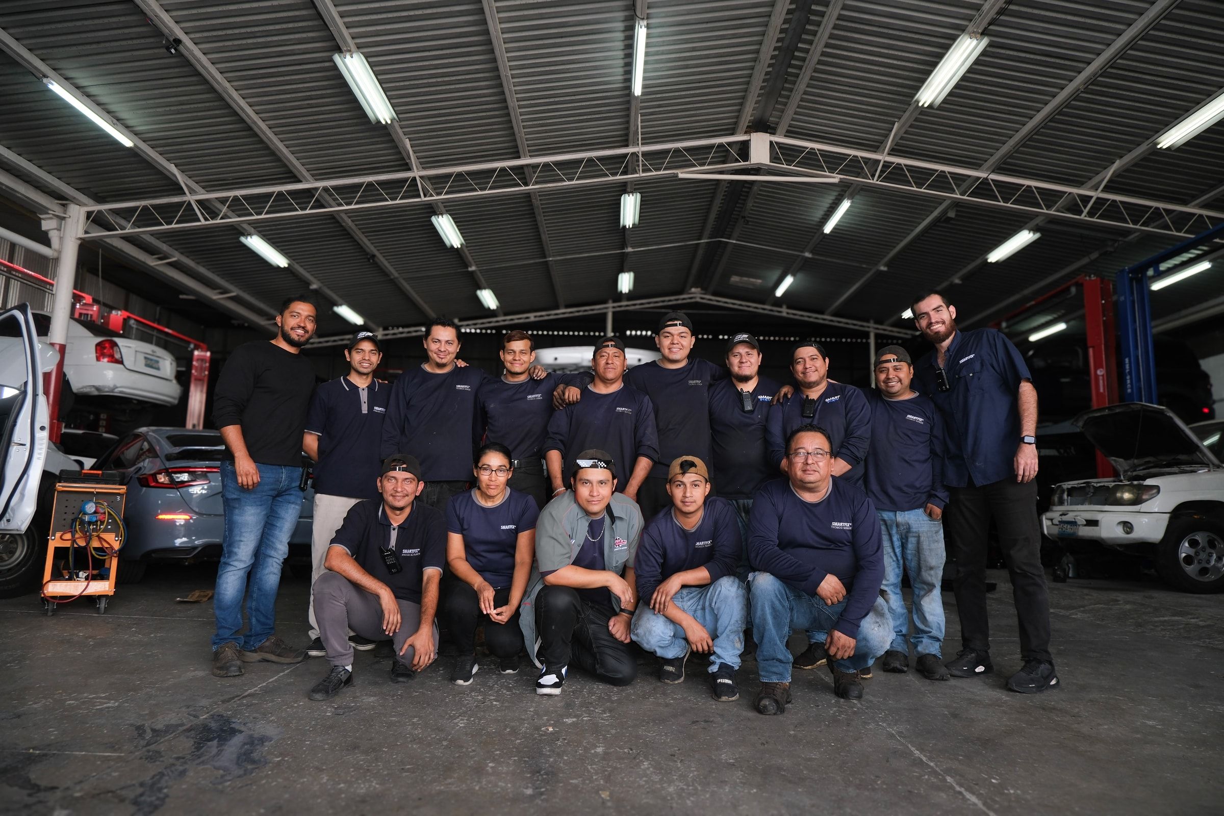 Equipo técnico completo de Smartfix, uniformado, en la nave de trabajo