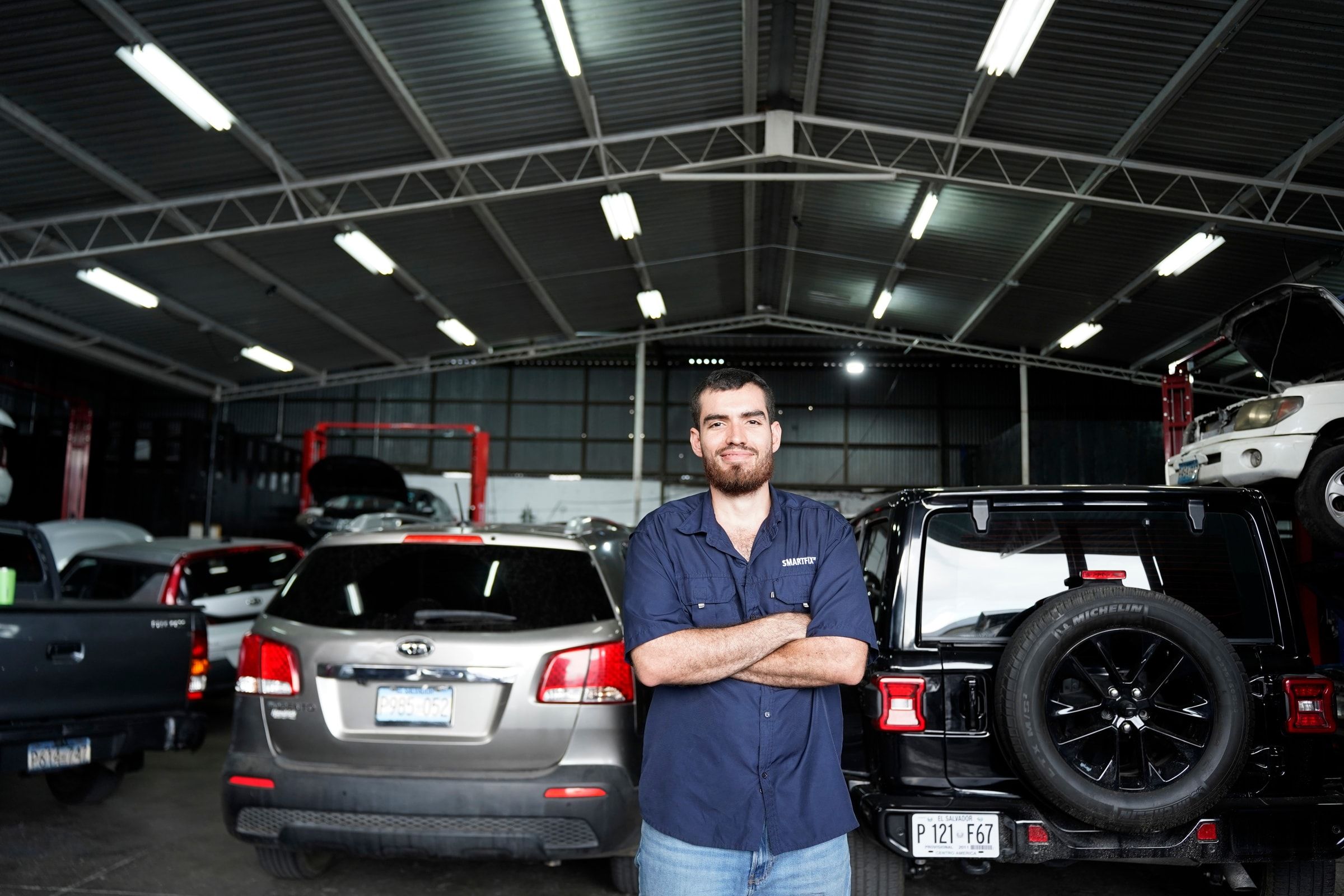 Retrato de Gustavo, ingeniero industrial y cofundador de Smartfix, en uniforme de taller